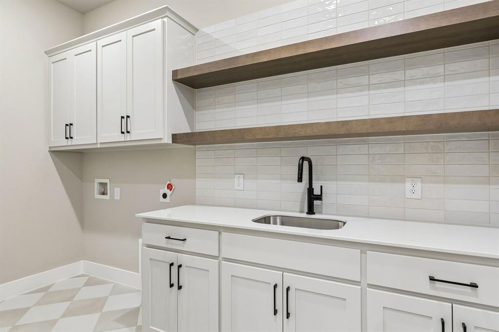 4512 Meander Way Prosper, TX 75078 - Photo 21 of 40 a kitchen with a sink and cabinets