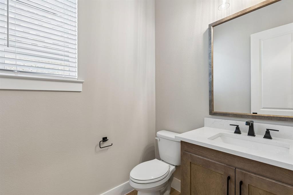 4512 Meander Way Prosper, TX 75078 - Photo 28 of 40 a bathroom with a granite countertop sink toilet a mirror and a window