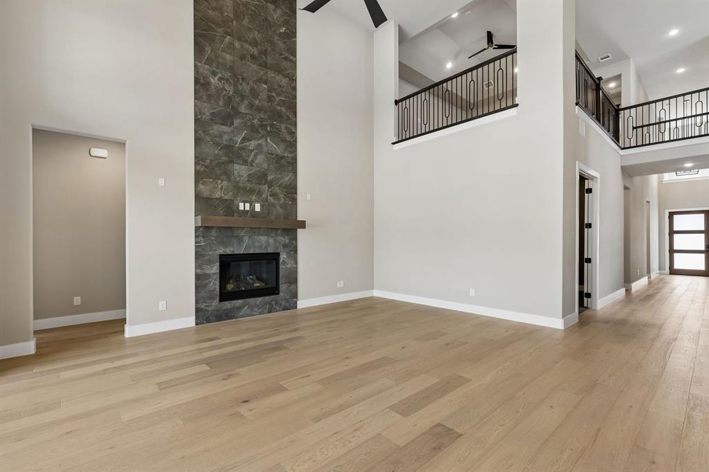 4512 Meander Way Prosper, TX 75078 - Photo 3 of 40 a view of a livingroom with wooden floor and a fireplace