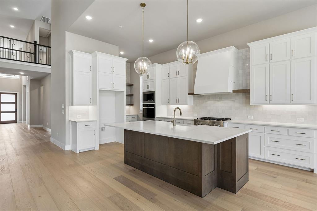 4512 Meander Way Prosper, TX 75078 - Photo 8 of 40 a large kitchen with kitchen island a sink stainless steel appliances and cabinets