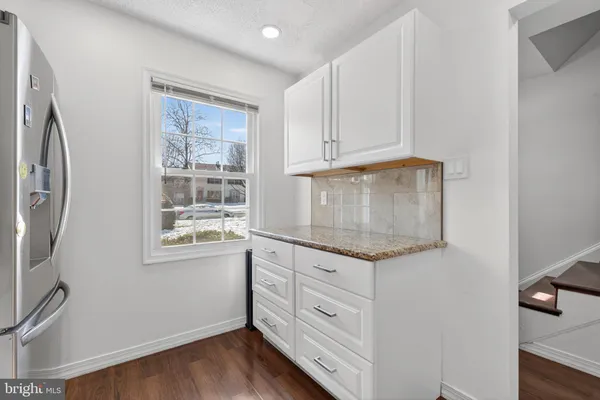 a kitchen with granite countertop cabinets appliances and a window