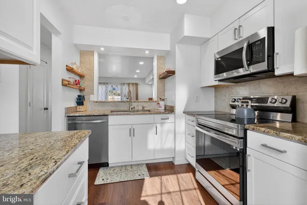 a kitchen with stainless steel appliances granite countertop a sink and stove top oven
