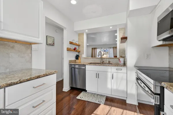 a kitchen with granite countertop cabinets stainless steel appliances and a counter space