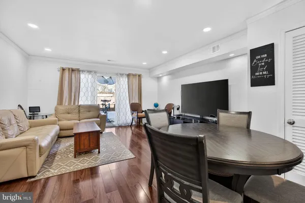 a living room with furniture a flat screen tv and a large window