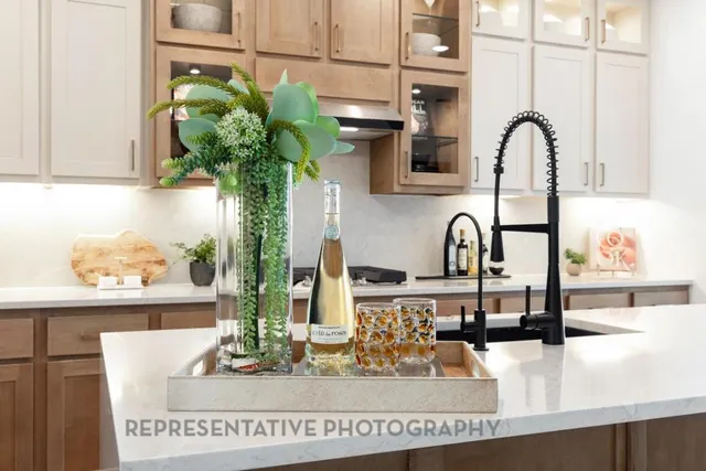 a very nice looking kitchen with granite countertop kitchen island stainless steel appliances a table and chairs