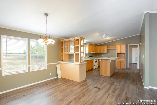 a kitchen with refrigerator and wooden floor