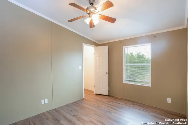 a view of an empty room with window and a fan