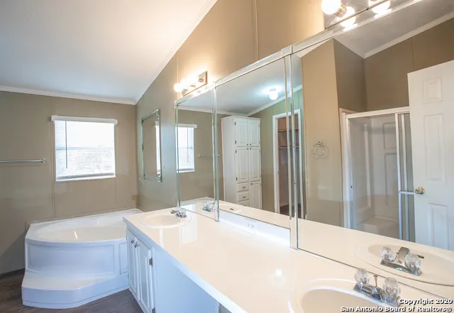 a bathroom with a tub a sink and mirror