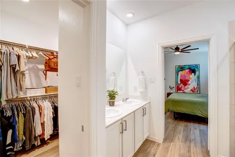a hallway with white cabinets and a wooden floor