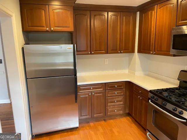 a kitchen with stainless steel appliances granite countertop a refrigerator and a stove top oven