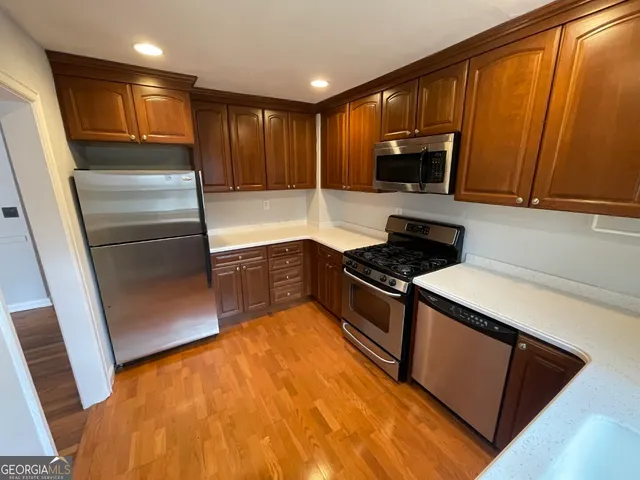 a kitchen with granite countertop stainless steel appliances and wooden cabinets