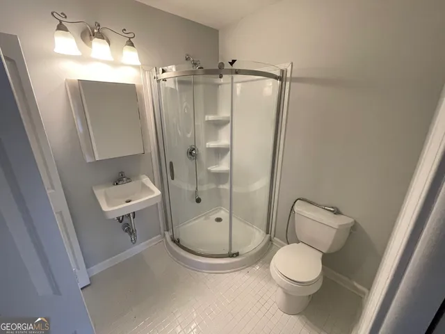 a bathroom with a toilet a sink and shower