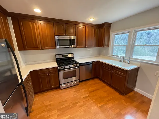 a kitchen with wooden cabinets and stainless steel appliances