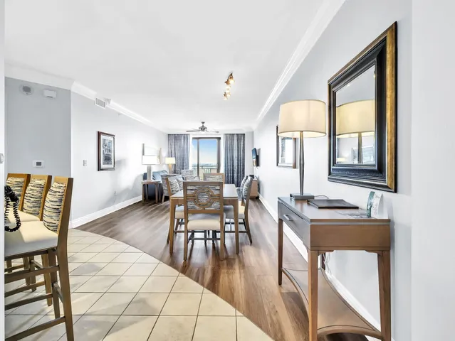 a living room with furniture a flat screen tv and kitchen view