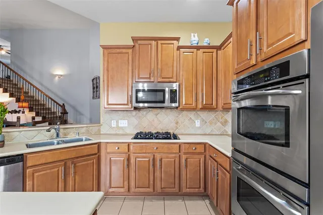 a kitchen with granite countertop a sink stove and microwave