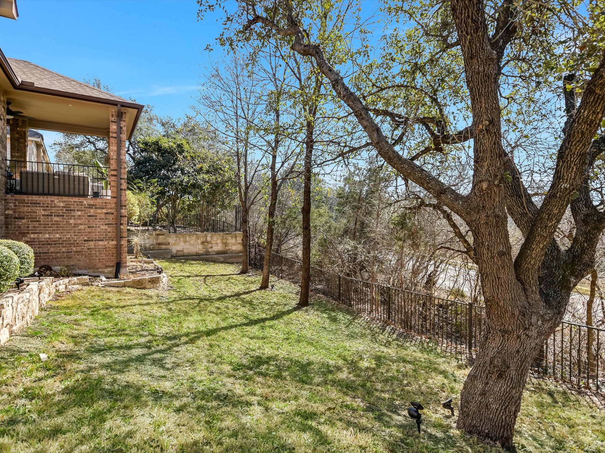 201 Bellagio Drive Austin, TX 78734 - Photo 28 of 31 The fenced yard features wrought iron fencing and mature shade trees.