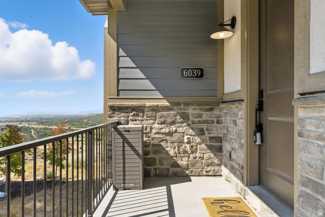 6039 North Westridge Road Heber City, UT 84032 - Photo 21 of 22 Stone veneer facade with horizontal siding details and an outdoor wall sconce
