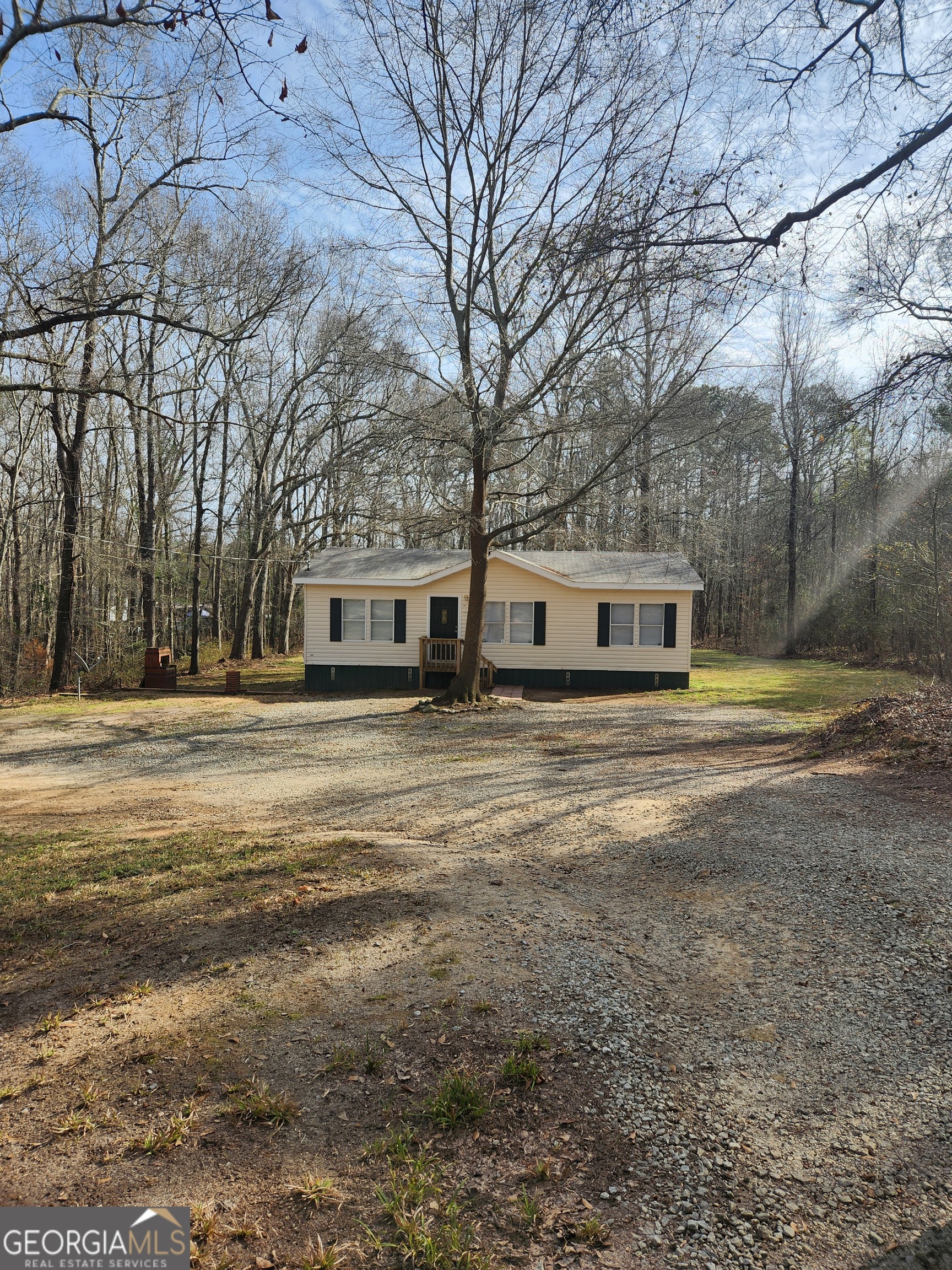 a front view of house with yard and trees around
