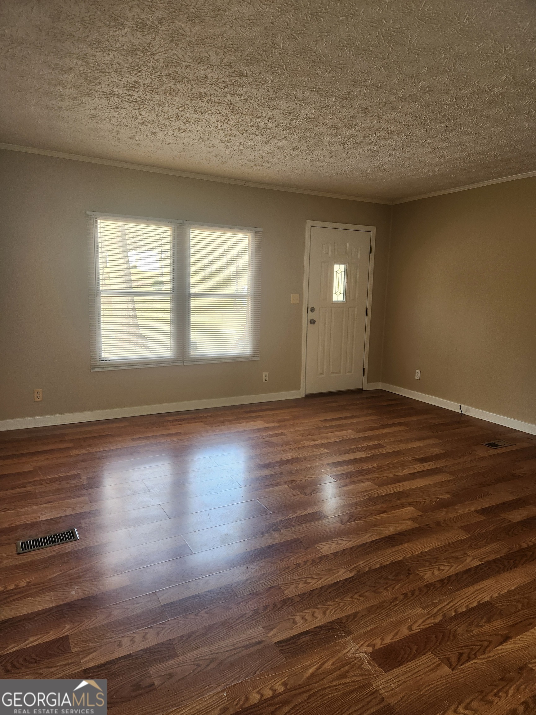 88 Dry Creek Road Danielsville, GA 30633 - Photo 6 of 20 a view of an empty room with wooden floor and a window