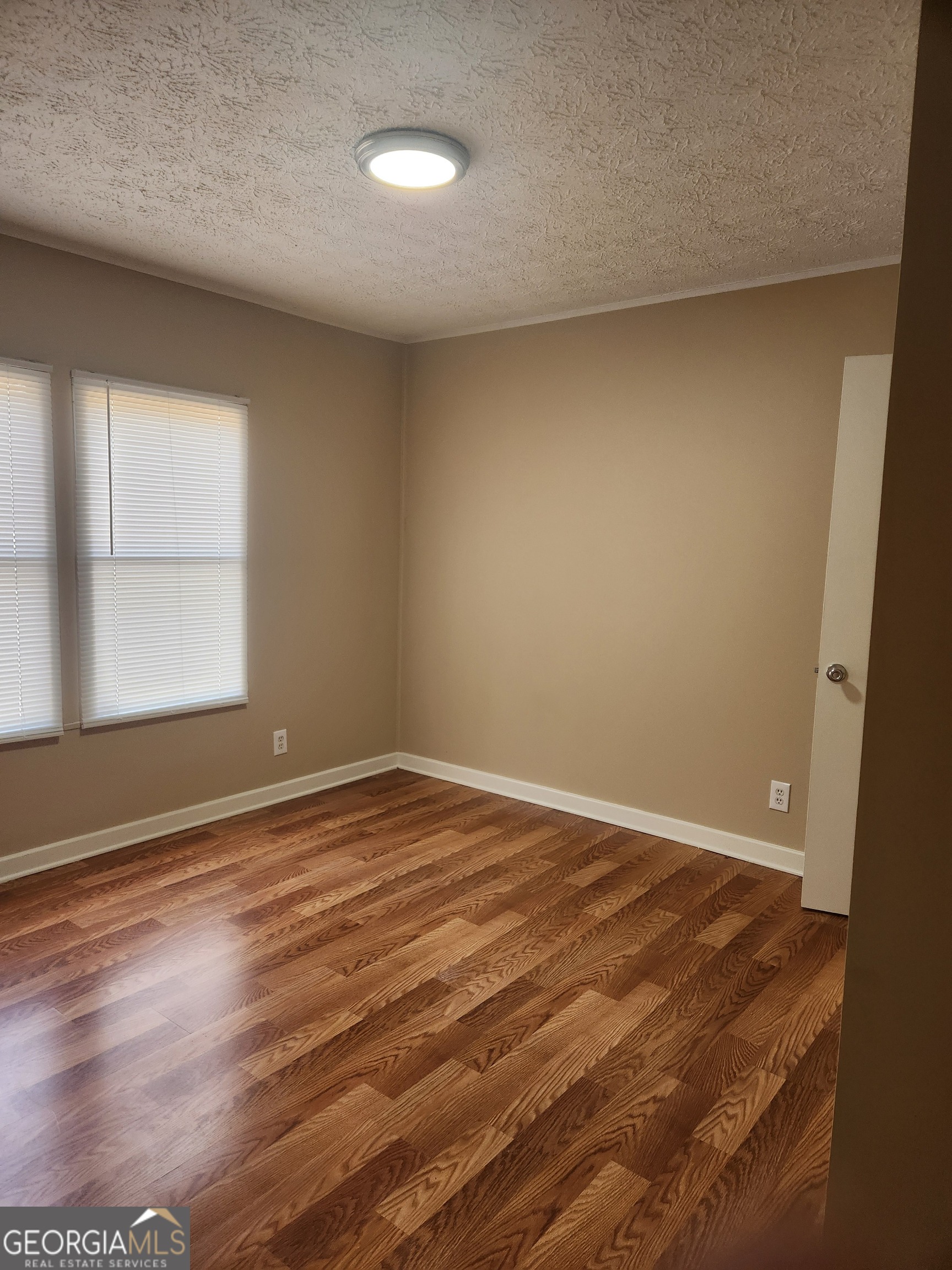 88 Dry Creek Road Danielsville, GA 30633 - Photo 9 of 20 an empty room with wooden floor and windows