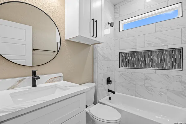 a bathroom with a sink a toilet and a mirror