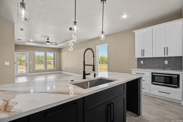 a kitchen with a sink a center island and stainless steel appliances