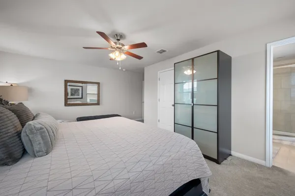 a spacious bedroom with a bed and a chandelier