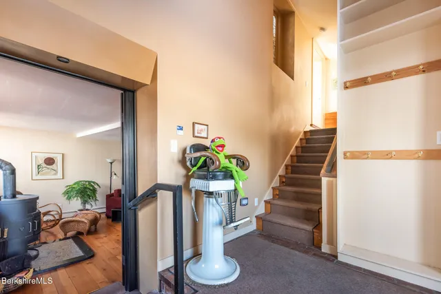 a bedroom with a bed a chair and potted plant on the dresser