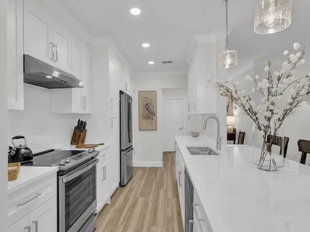 a kitchen with stainless steel appliances granite countertop a lot of counter space and wooden floor