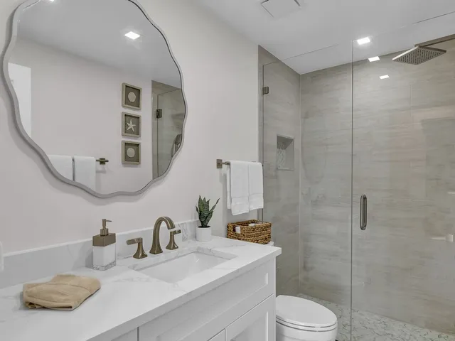 a bathroom with a sink a toilet and a mirror