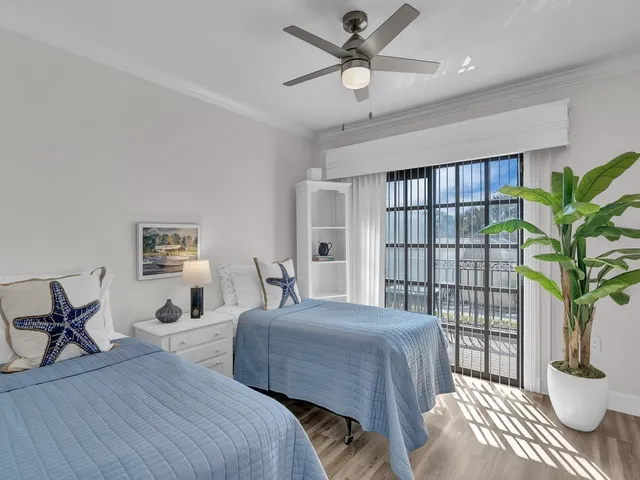 a bedroom with a balcony a bed and a potted plant