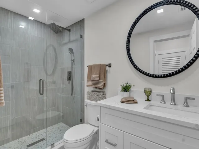 a bathroom with a sink a toilet and shower