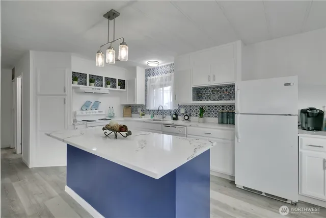 a kitchen with kitchen island a sink appliances and cabinets