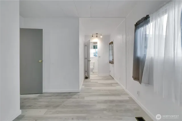 a view of a hallway with wooden floor and staircase