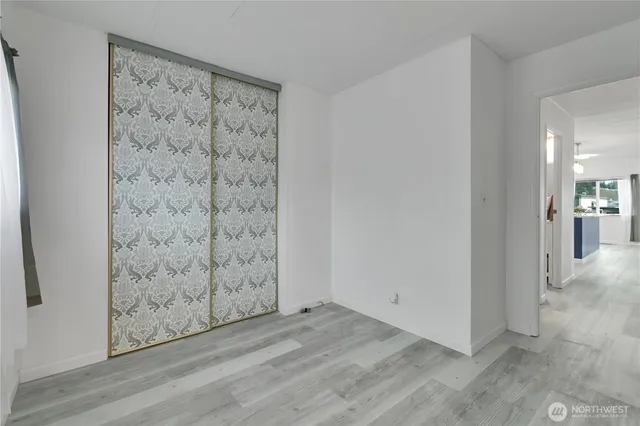 a view of a hallway with wooden floor and closet