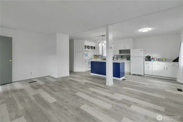 a view of kitchen with stainless steel appliances wooden floor and large window