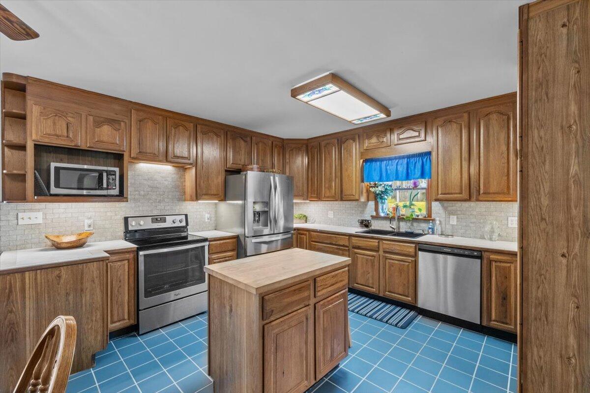 1937 Kunkletown Road Saylorsburg, PA 18353 - Photo 11 of 51 a kitchen with stainless steel appliances a sink stove refrigerator granite counter tops and wooden cabinets