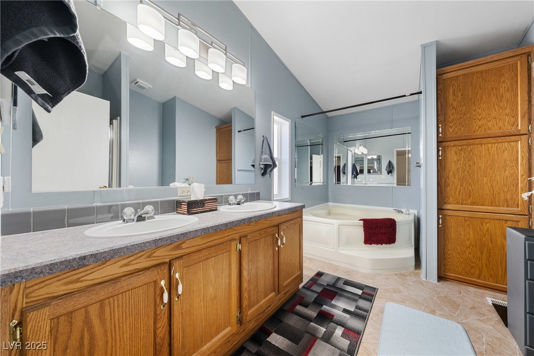 633 East Simkins Road Pahrump, NV 89060 - Photo 12 of 25 Primary bathroom with a garden tub, double vanity, and a sink