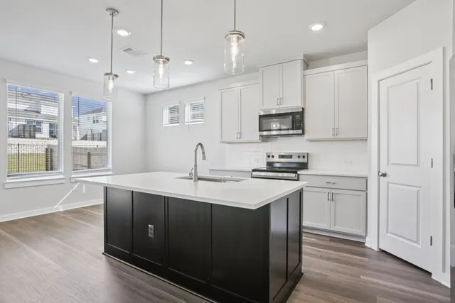 a kitchen with kitchen island white cabinets and stainless steel appliances
