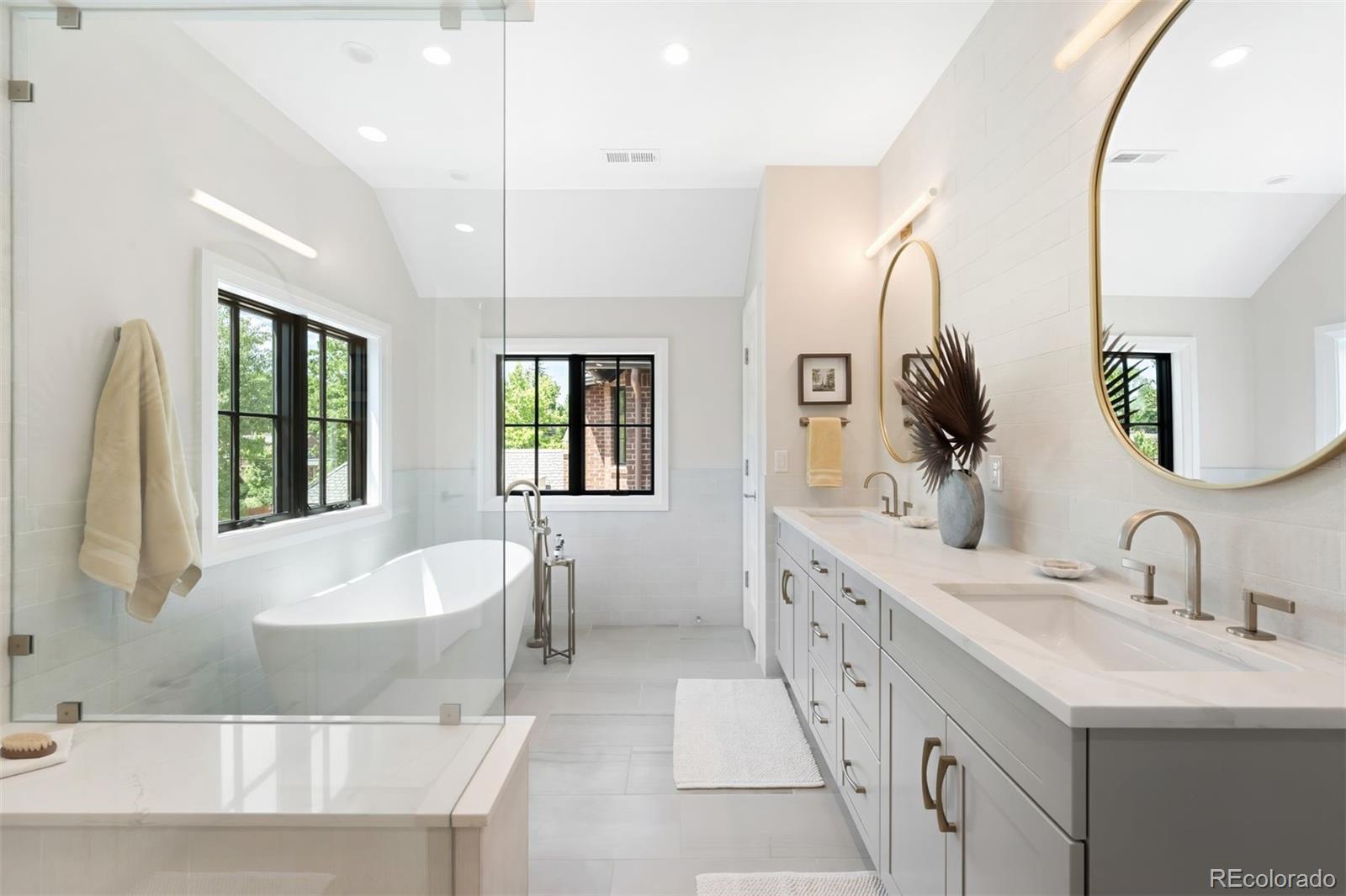 2237 South Madison Street Denver, CO 80210 - Photo 19 of 44 a spacious bathroom with a double vanity sink a mirror and a bathtub