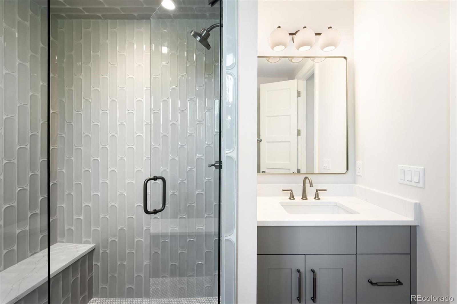 2237 South Madison Street Denver, CO 80210 - Photo 31 of 44 a bathroom with a sink a mirror and shower