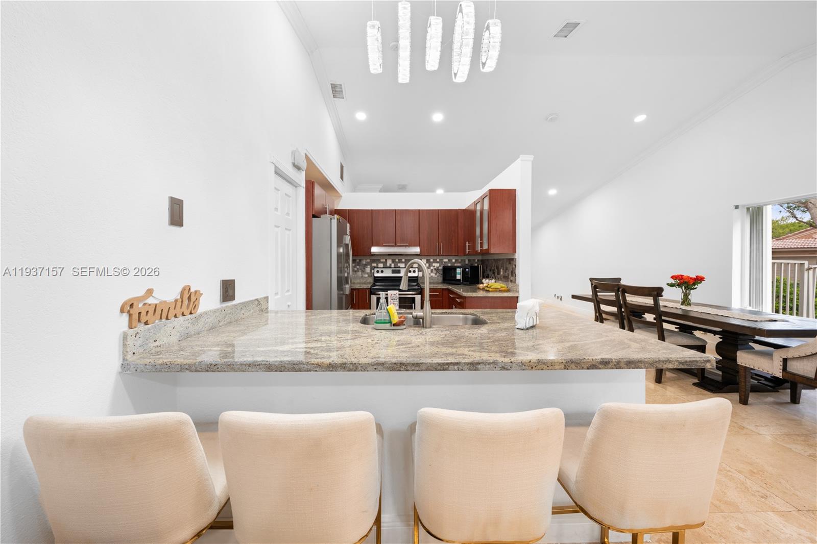 4361 Mahogany Ridge Drive Weston, FL 33331 - Photo 24 of 47 a kitchen with stainless steel appliances kitchen island granite countertop a table and chairs