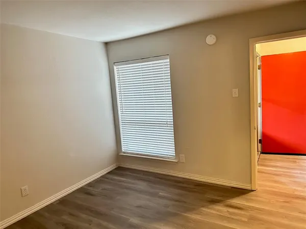 an empty room with wooden floor and a window