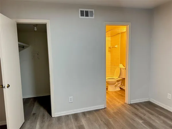 an empty room with a closet and wooden floor