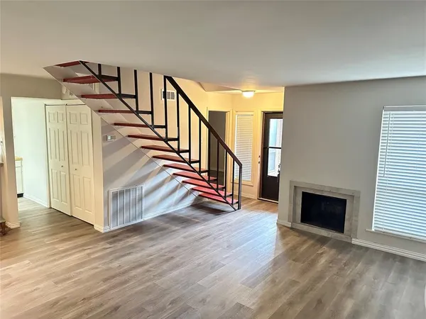 a view of a livingroom with wooden floor and stairs
