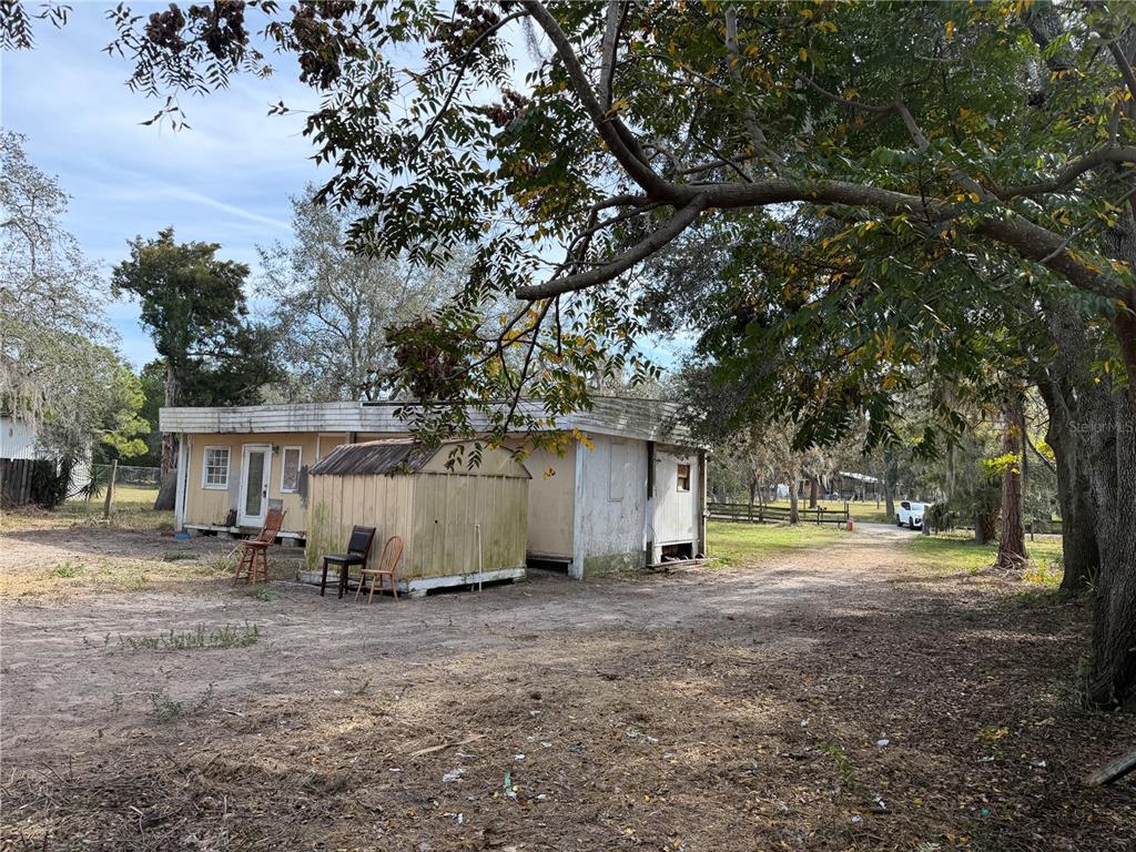 10711 Jacamar Drive New Port Richey, FL 34654 - Photo 17 of 19 a view of backyard with large trees and wooden fence
