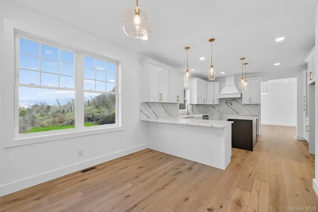 a large kitchen with kitchen island a large counter top space a sink stainless steel appliances and cabinets