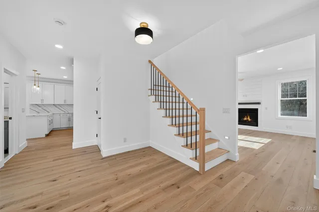 a view of a hallway with wooden floor and staircase