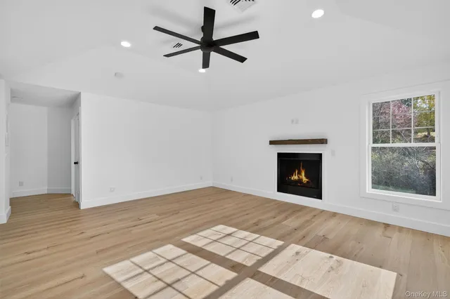 an empty room with windows and a fireplace