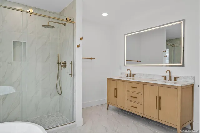 a bathroom with a double vanity sink toilet mirror and shower
